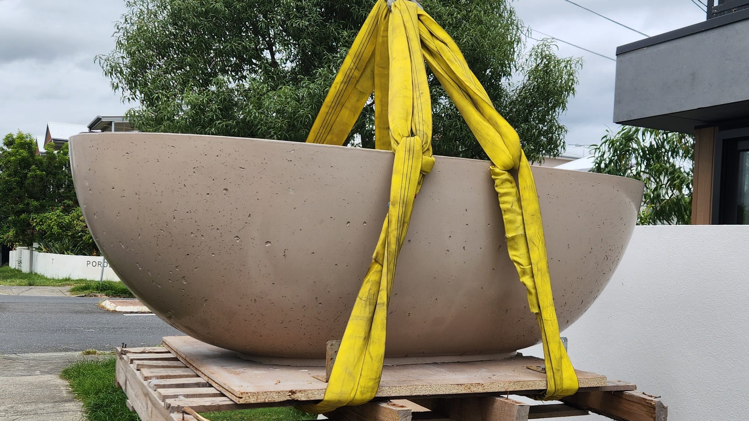 stone bath water sculpture being relocated using crane