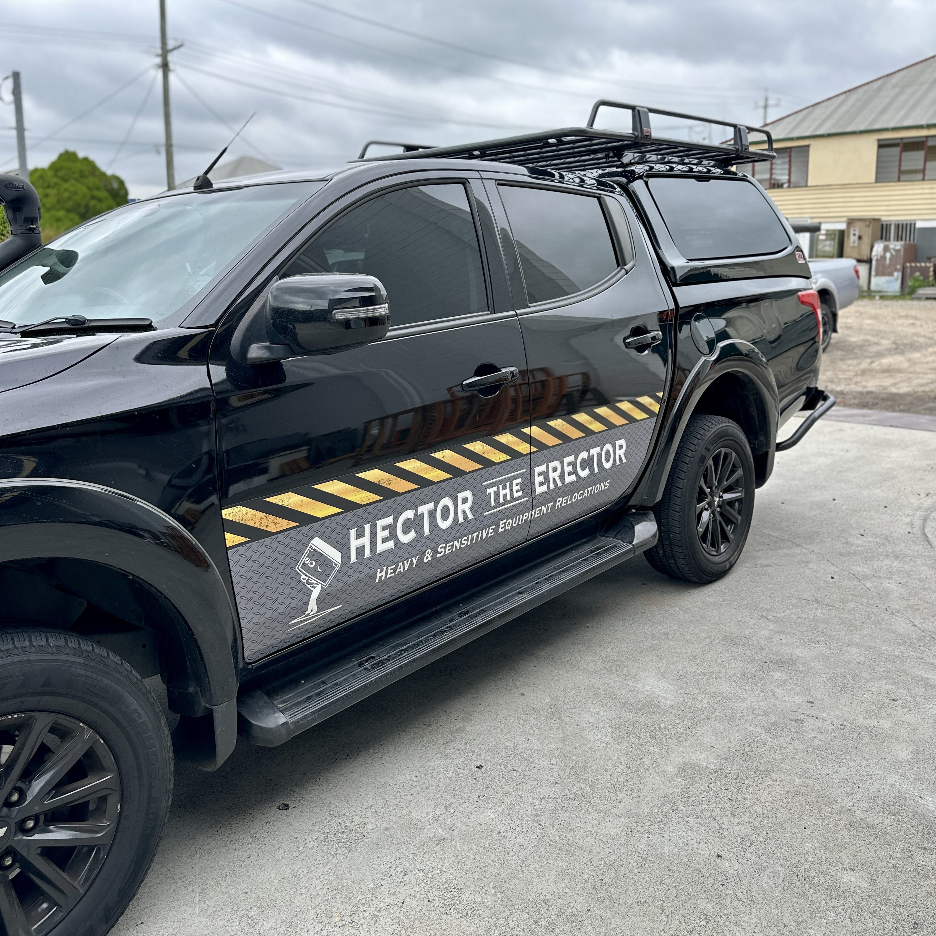 Hector the Erector black Mitsubishi Triton work ute with decal